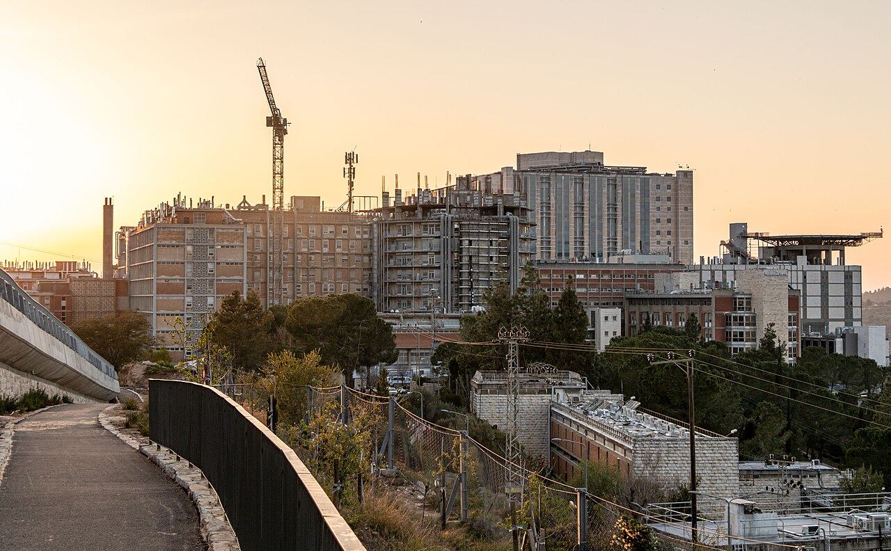 תמונת חדשות של עיר עם מבנים רבים, חלקם בבנייה, בשעת שקיעה.