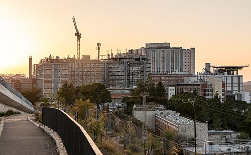 תמונת חדשות של עיר עם מבנים רבים, חלקם בבנייה, בשעת שקיעה.